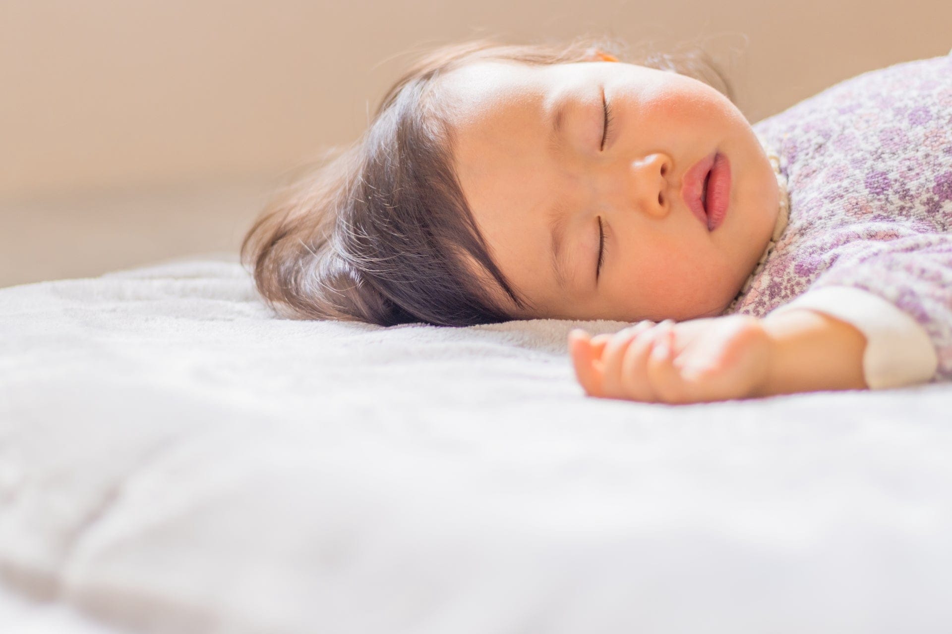 布団に横たわって眠る高齢の女性
