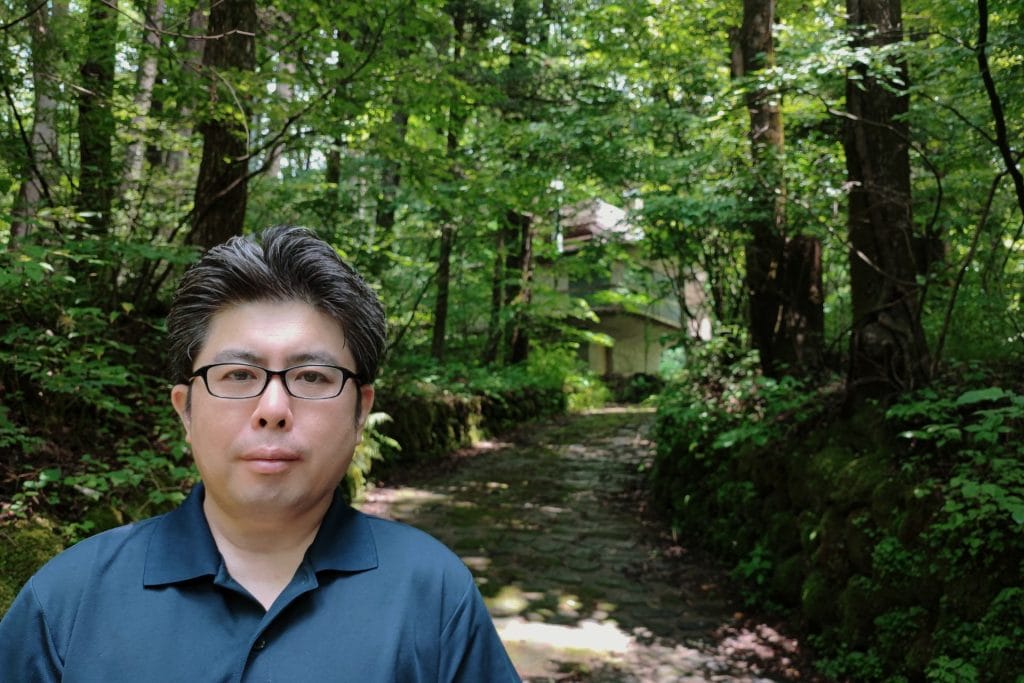 木立に続く小径と、建築工房akitsu代表の建築士
